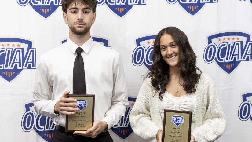 Reagan Zangla and George Gachechiladz hold their awards while posing for the camera in front of an OCIAA backdrop