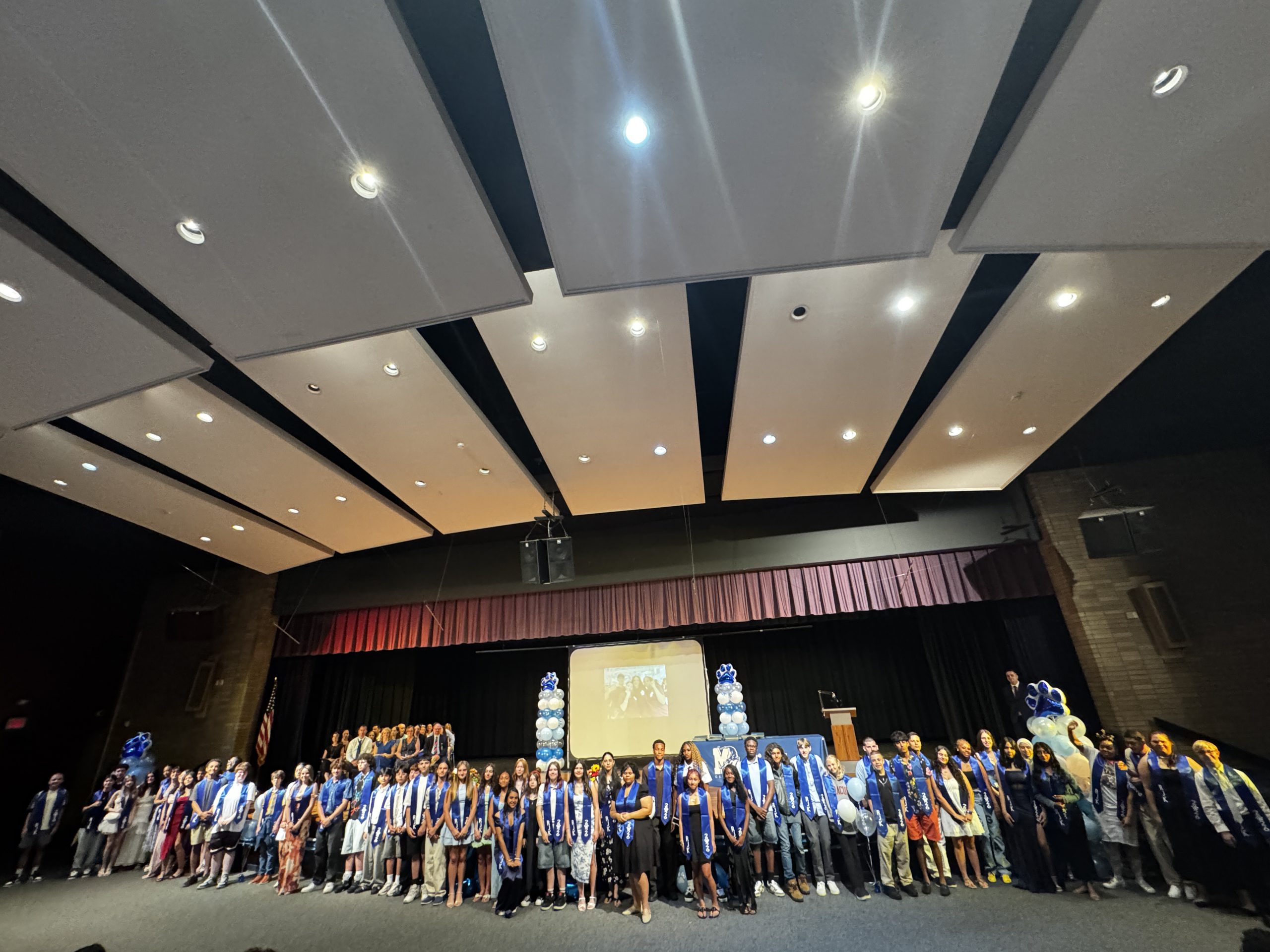 students who earned a class award pose on stage