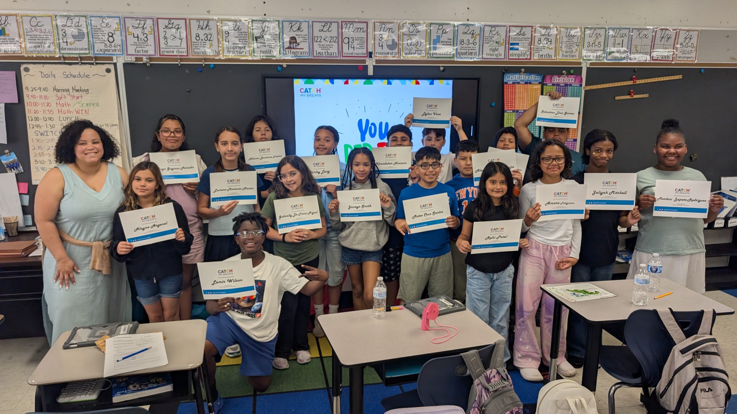 a group of students who participated in the Catch my breath program hold up their certificates of completion 