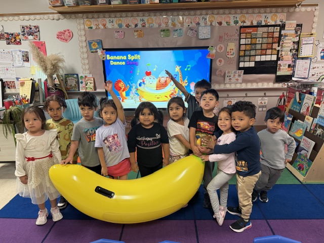 small children pose with a large inflatable banana