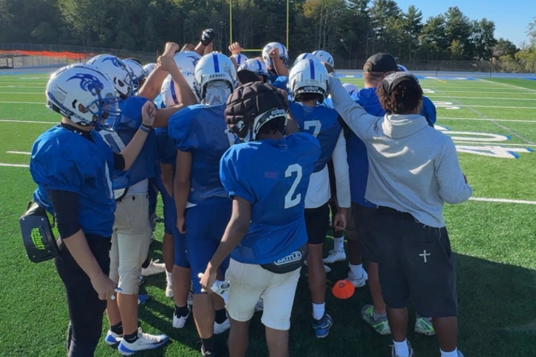 a group of football players high five on Ed Kennedy field